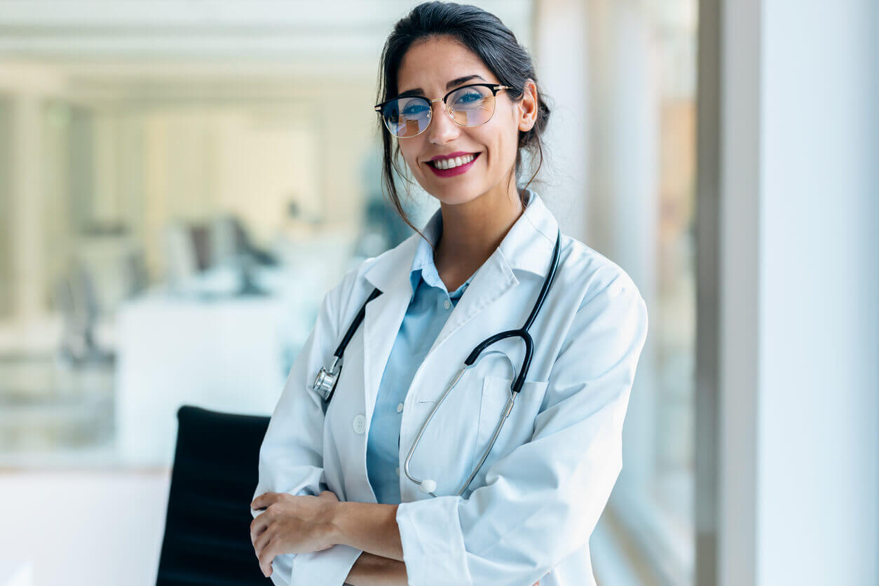 Smiling female holistic family doctor looking at camera in the medical consultation