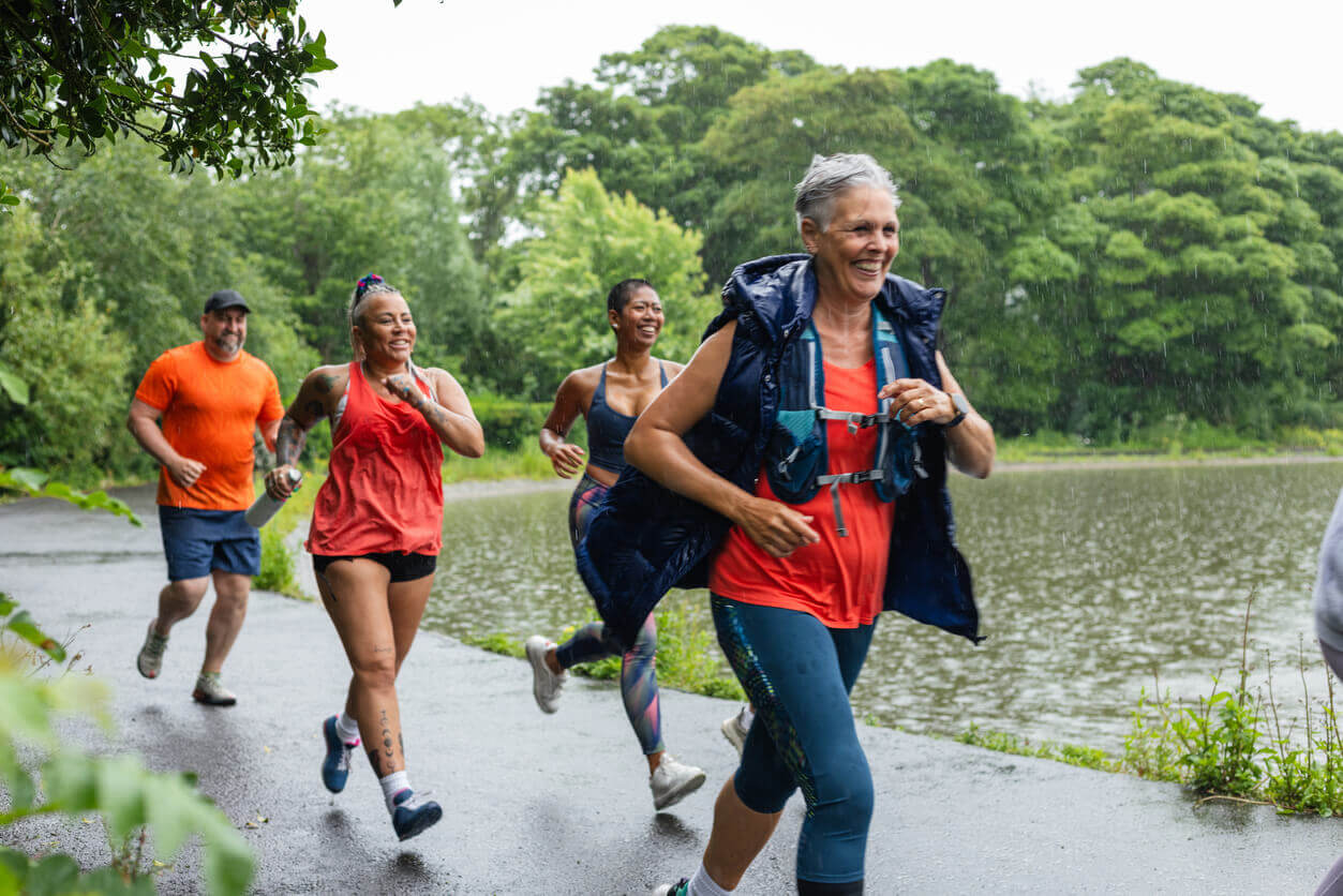 A group of people (female and male) exercising by running